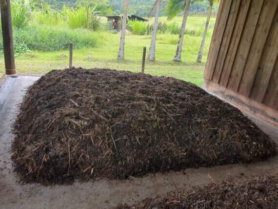 Imagem do processo de compostagem de esterco de gado na Vila Verde, transformando resíduos em adubo orgânico.